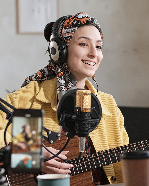 A music creator playing a guitar on a show